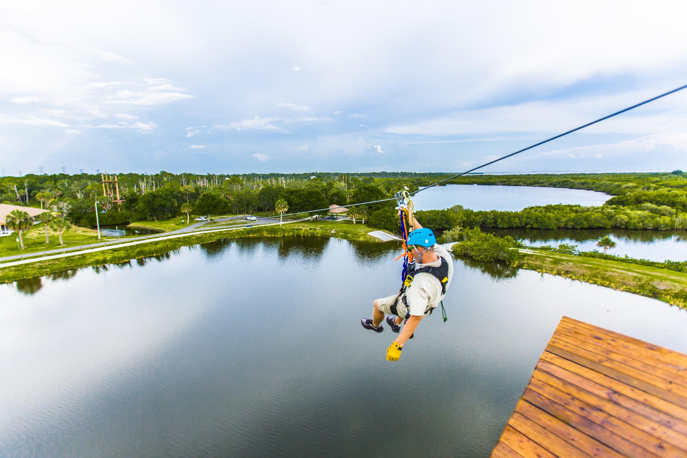 A man descends a zip line at Empower Adventures