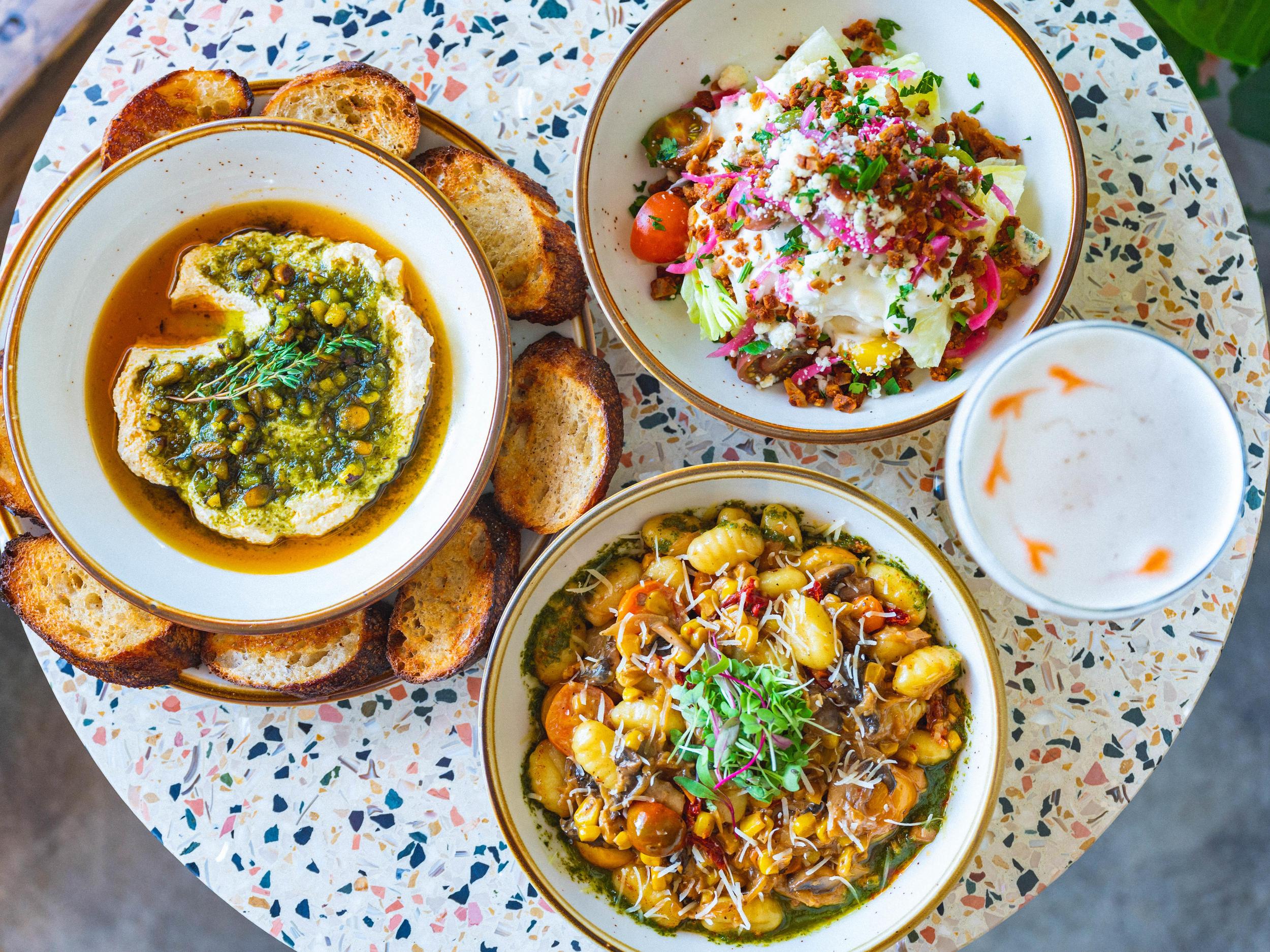 Three vegan dishes on a speckled table