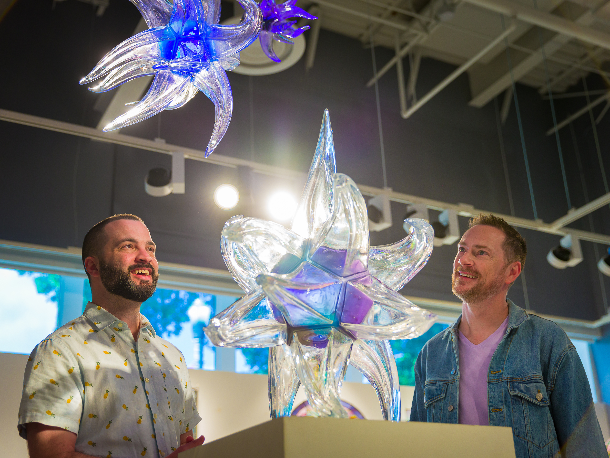A gay couple looks at glass art at the Imagine Museum.