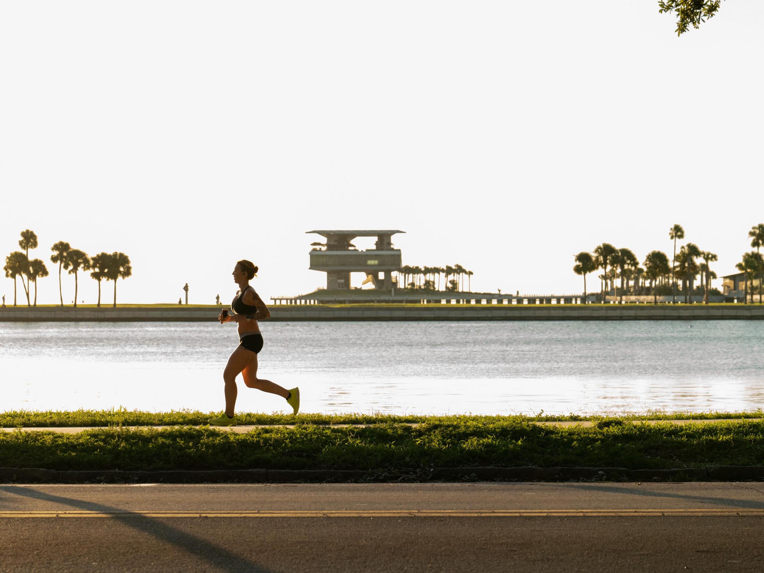 a runner near Tampa Bay with the St. Pete Pier in the background
