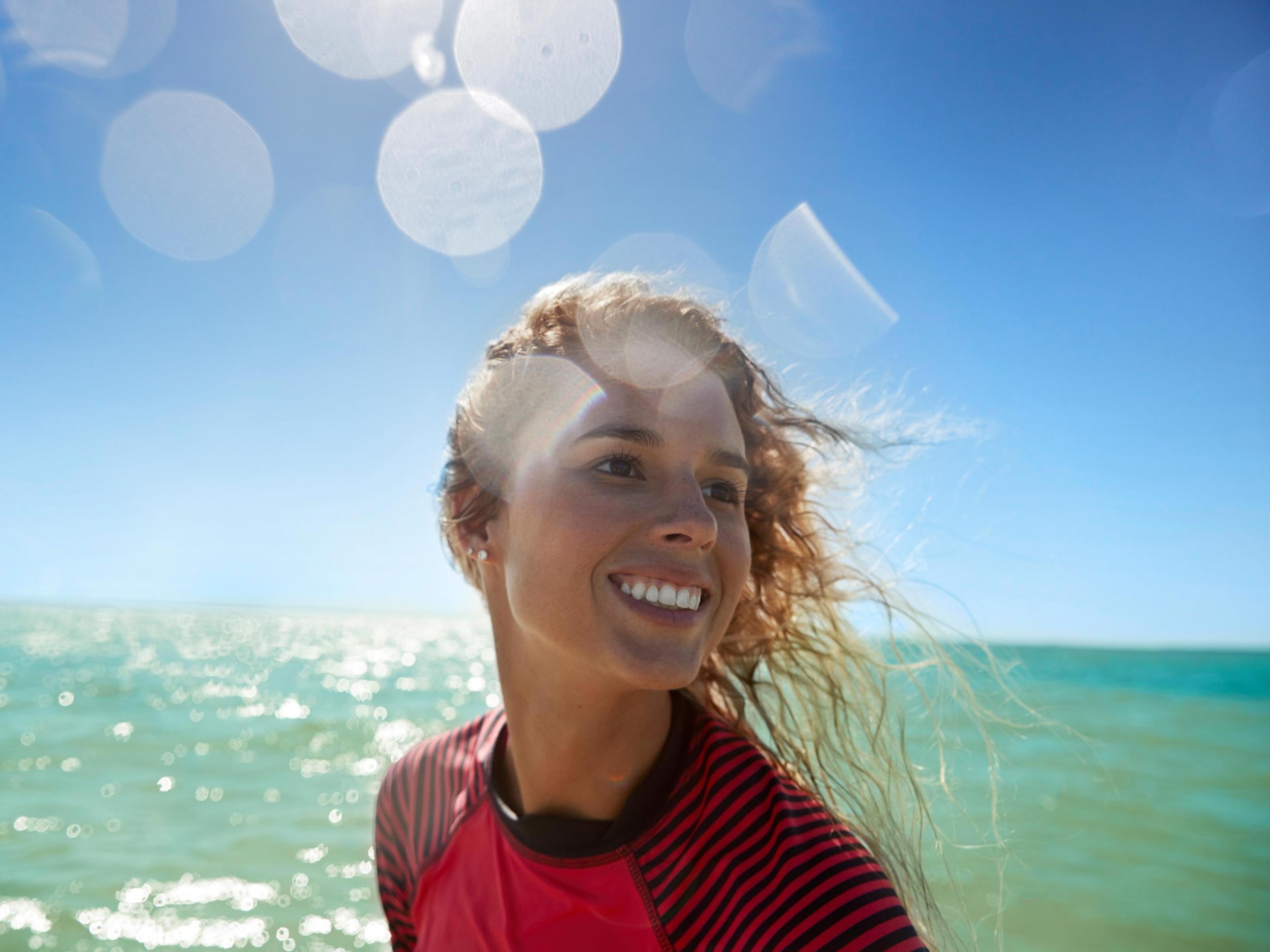 a close-up image of a smiling woman on a paddleboard at Anclote Key