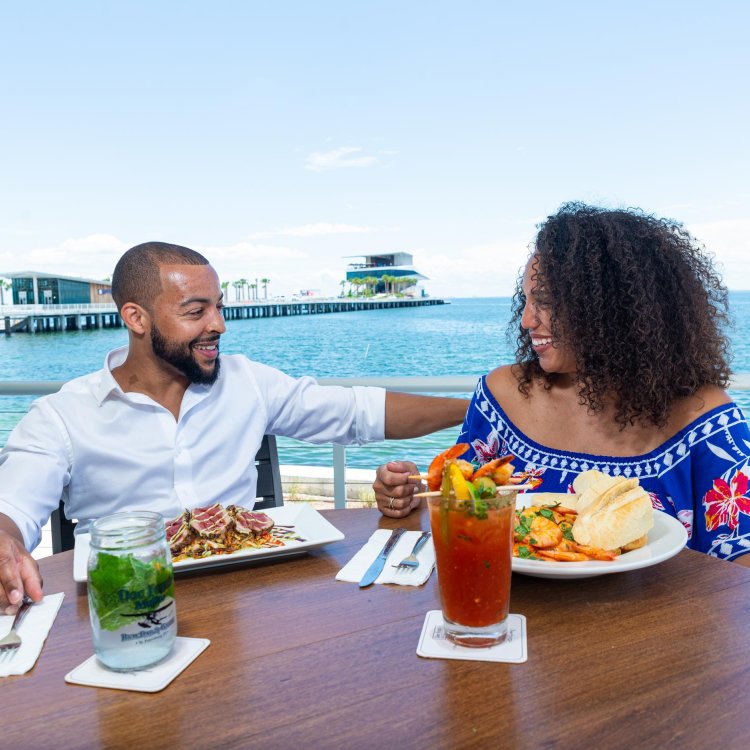 A couple dines and enjoys cocktails at Doc Ford's Rum Bar & Grille with the St. Pete Pier in the background