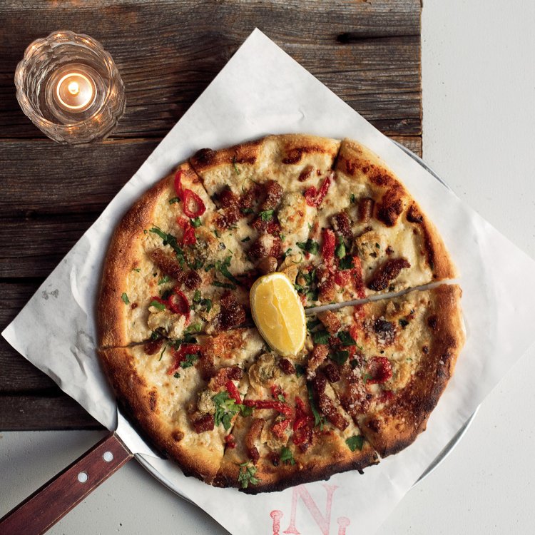 A pizza from Noble Crust with a lemon wedge on top
