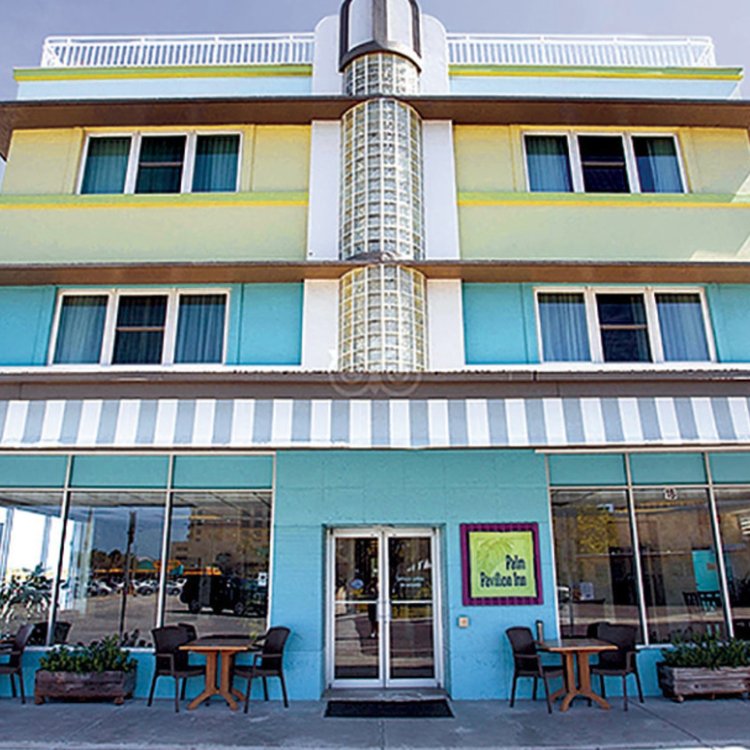 An exterior shot of a hotel that is blue and yellow.