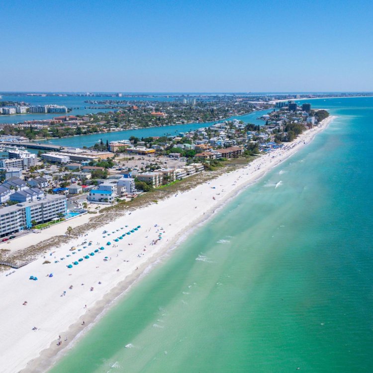 An aerial view of the ocean, beach and buildings along the shore