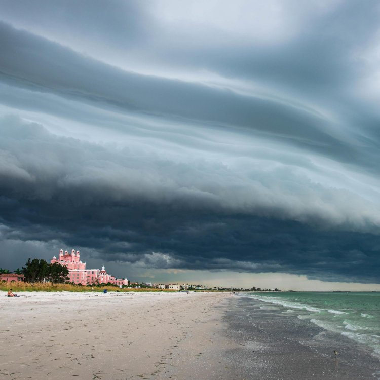an enormous and dramatic storm cloud over the beach and the don cesar pink hotel