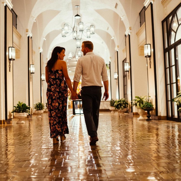 a woman and a man walk down a shiny tiled hallway with arched ceilings at the Vinoy Resort & Golf Club