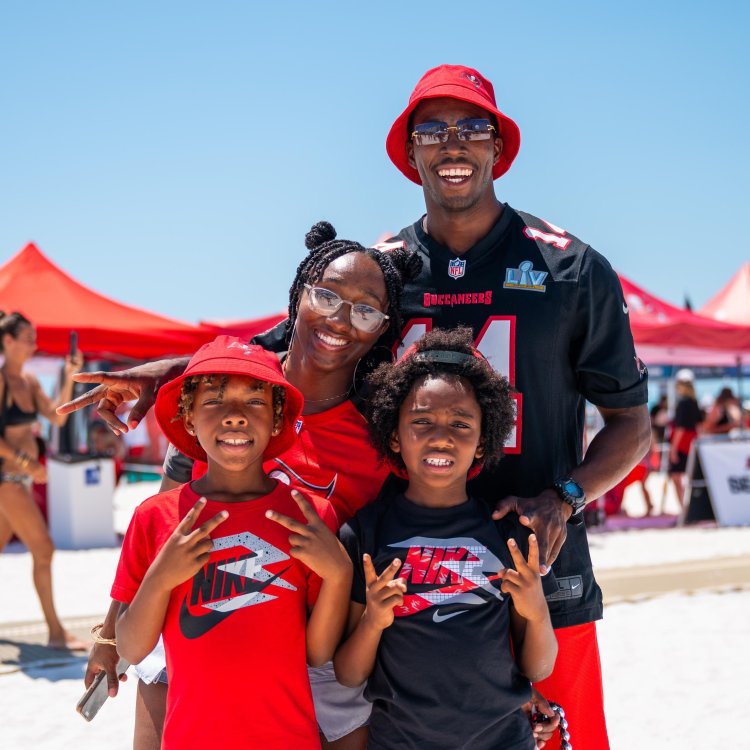 A family poses infront of a camera at Bucs Beach Bash