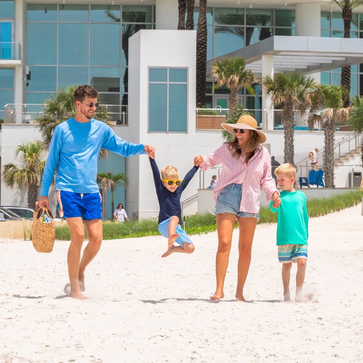 a couple with two young boys walks from Opal Sands out onto Clearwater Beach