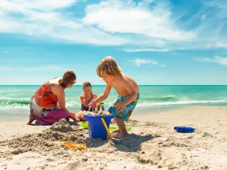 A family building a sand castle on the beach in Treasure Island.
