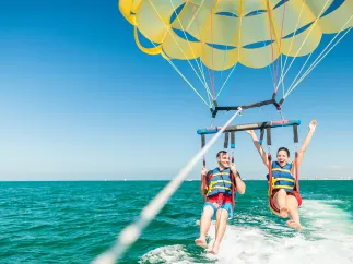 A couple taking flight in a parasail in Clearwater Beach.