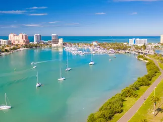 An aerial view of Clearwater Marina and Memorial Causeway showing green waters and bright blue sky.