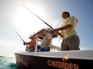 A group of men in a black boat fishing.
