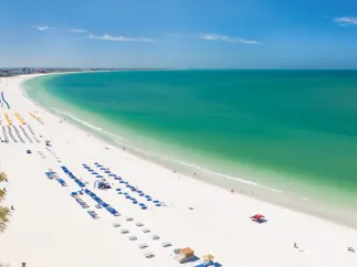 St. Pete Beach aerial panoramic photo showing the entire green waters beach, white sand and lots of hotels cabanas.