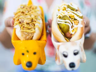 A woman holds up two vegan hot dogs
