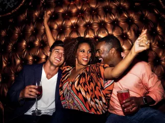 Three people dancing in a booth at Tryst Gastro Lounge