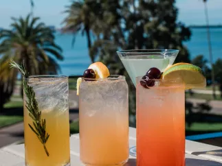 four cocktails on the railing of the Hi-Fi Cocktail at the Fenway Hotel