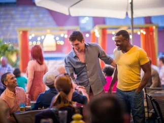 A couple men greet friends at a LGBT+ Bar and Restaurant