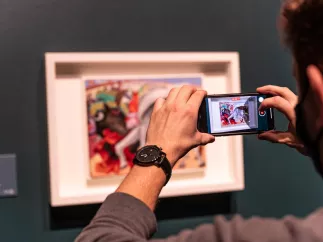 A museum guest takes a photo of a painting at the Dali Museum during the Picasso exhibit.