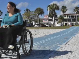 Woman in wheelchair on Mob-Mat on the beach