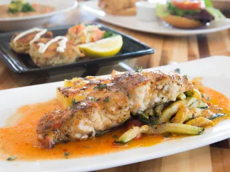Grouper on a dish with sauce and veggies