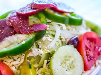 colorful greek salad with beets, green peppers, tomatoes, onions, feta cheese
