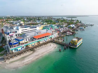 an aerial view of John's Pass Village & Boardwalk, a pier and a large boat