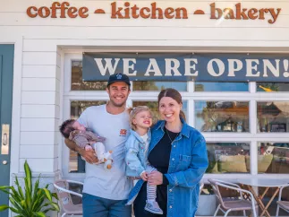 family standing in front coffee shop