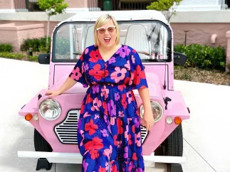 woman standing in front of pink car