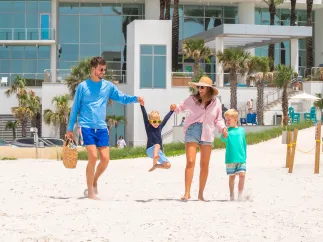 a couple with two young boys walks from Opal Sands out onto Clearwater Beach