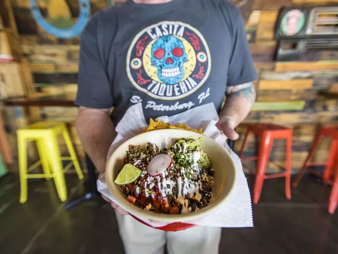 A waiter holds up a taco bowl from Casita Taqueria in downtown St. Pete