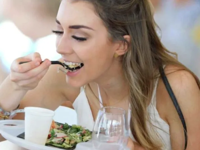 A woman eats a salad at Savor The Burg