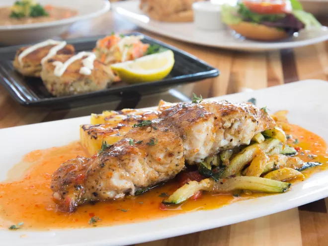 Grouper on a dish with sauce and veggies