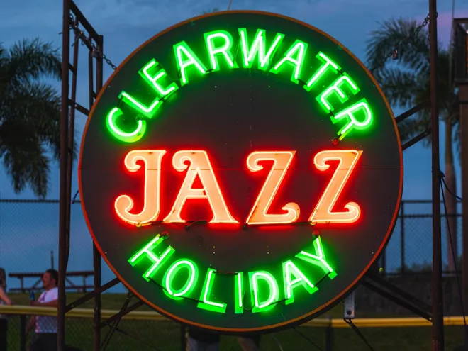 A lit neon Clearwater Jazz Holiday sign at dusk.