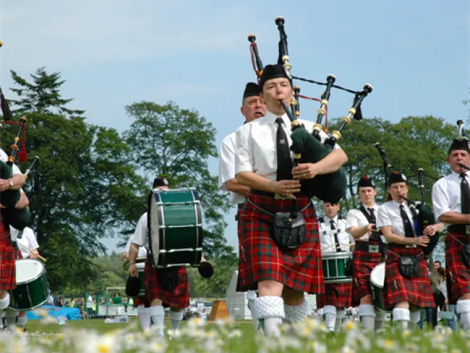 Band playing bag pipes in kilts. 