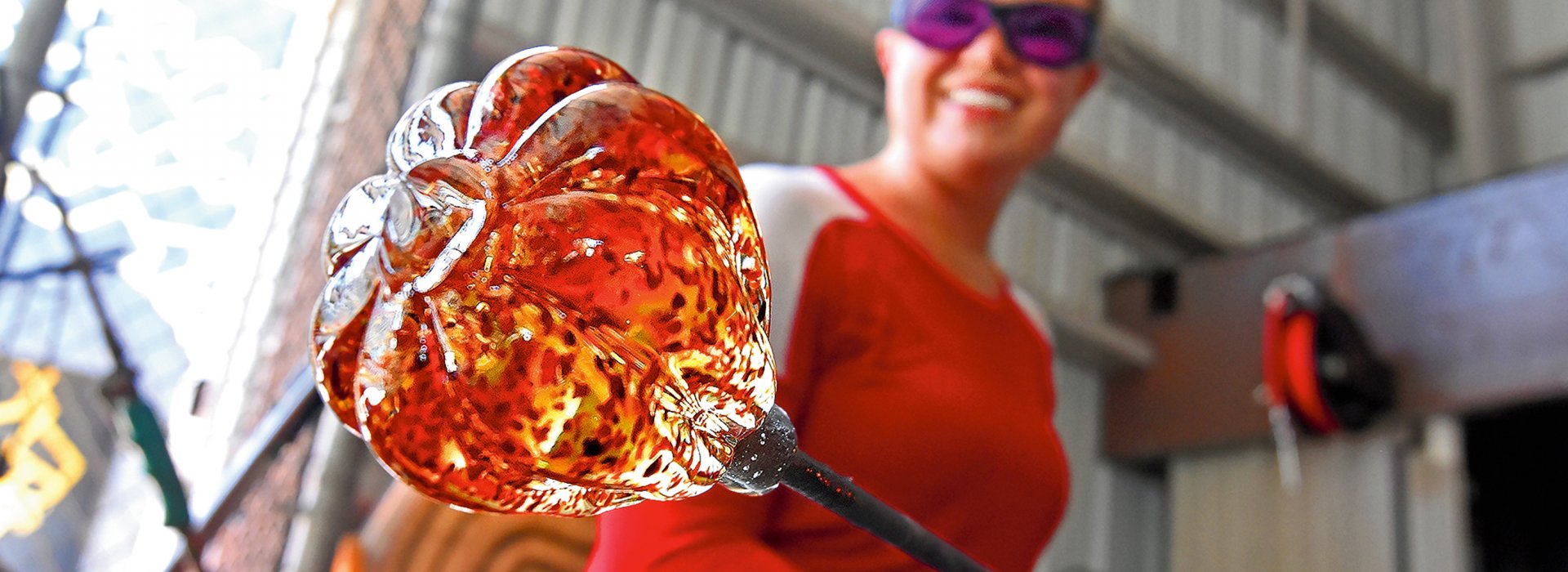 A glass artist shows off a work in progress at the hot shop at Morean Arts Center.
