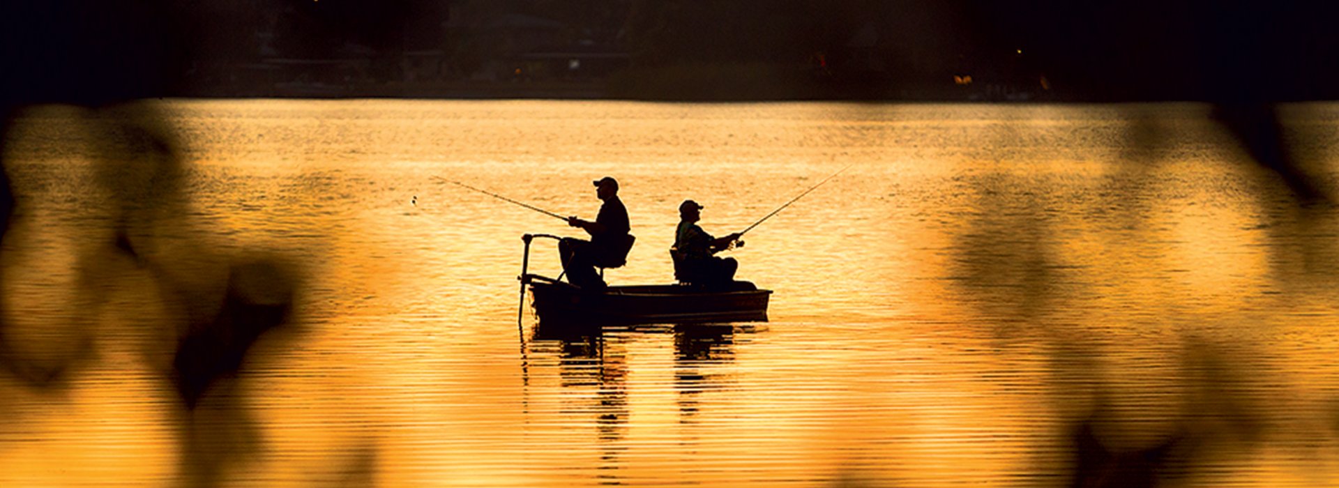 Silhouette of two men fishing at the Seminole Lake during sunset