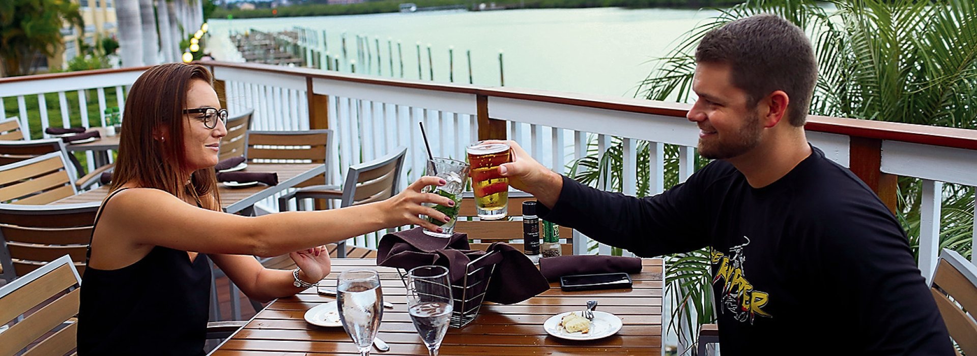 A couple toasts at a outdoor table at Salt Rock Grill