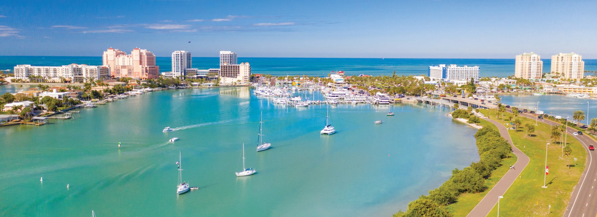 Clearwater Marina and Memorial Causeway overview showing sailboats, green waters and bright blue sky.