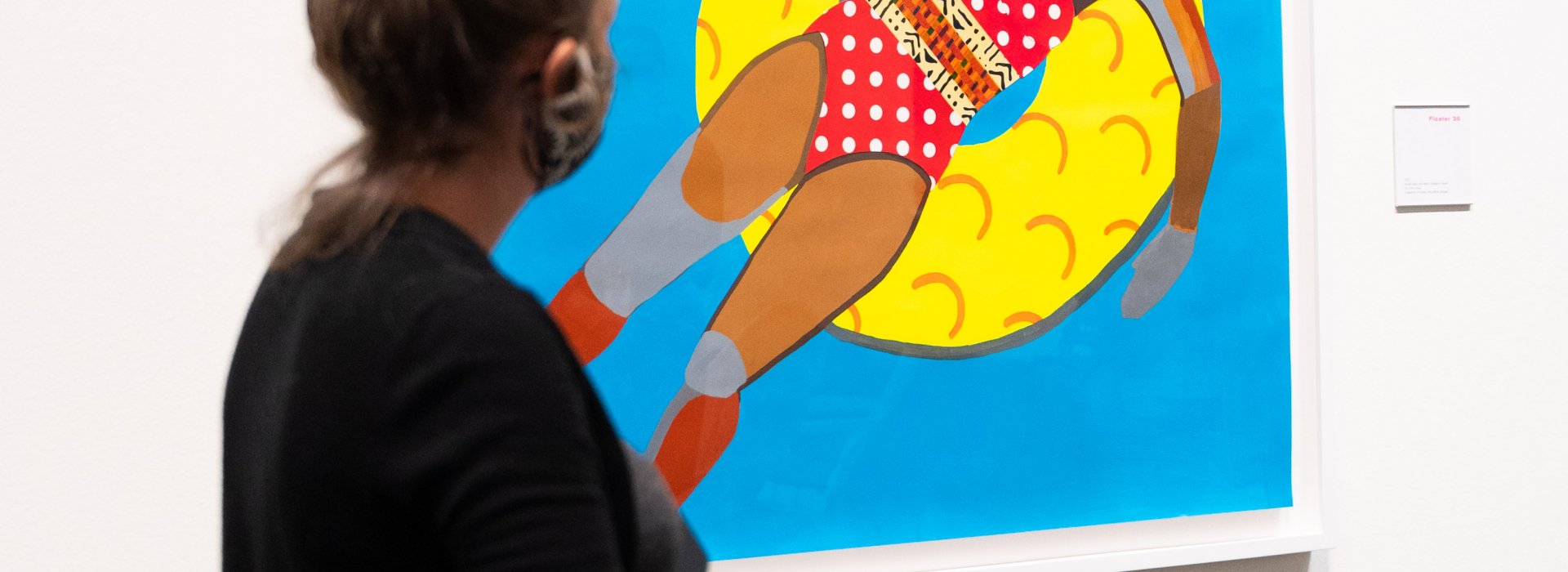 A woman seeing a painting of a person floating in a pool.