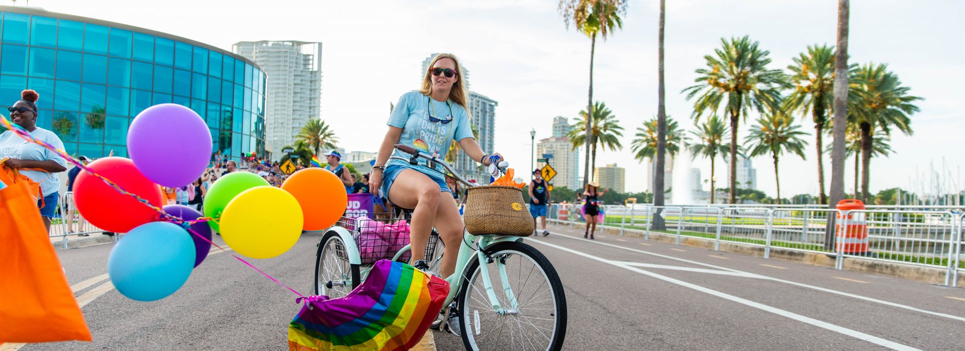 A person with colorful balloons tied to their bicycle riding during Pride parade in St. Pete.