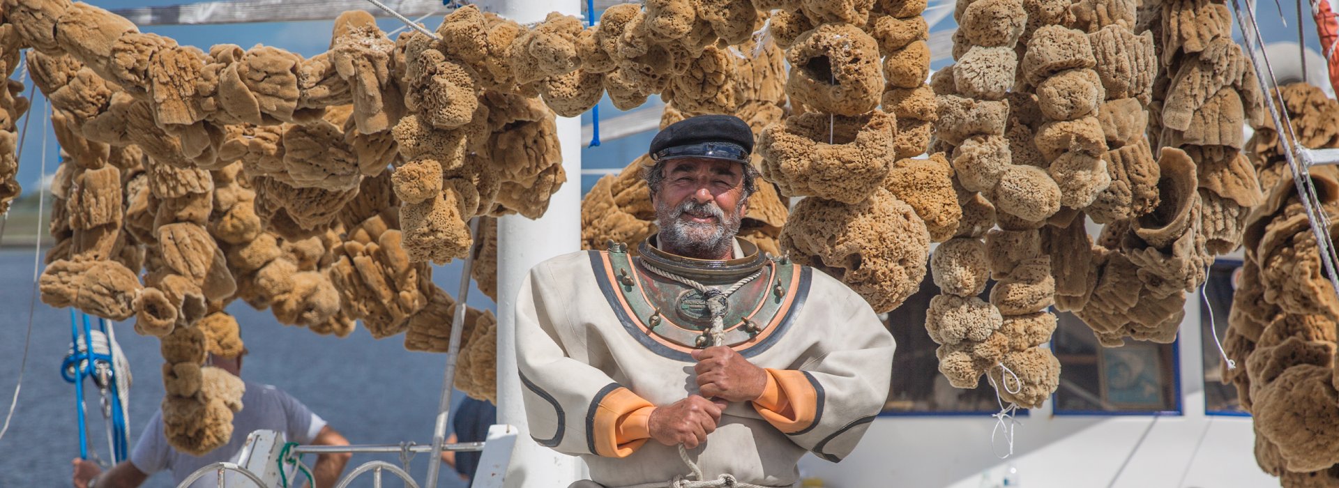 Um mergulhador de esponjas em um barco com muitas esponjas em Tarpon Springs.