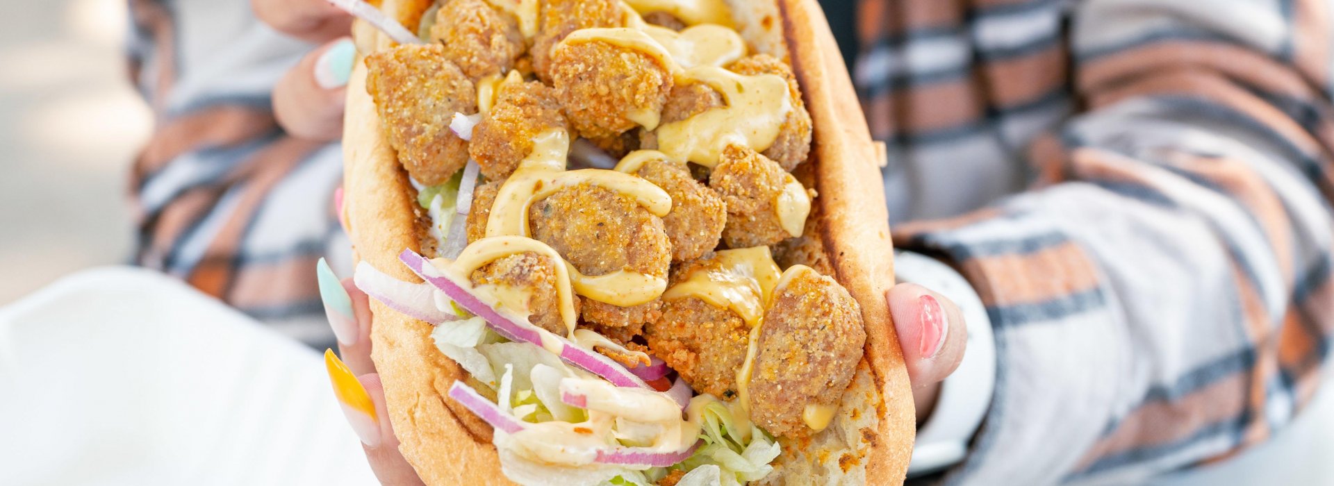 Close up view of a vegan sub with falafel, sauce and lettuce at Golden Dinosaurs in Gulfport