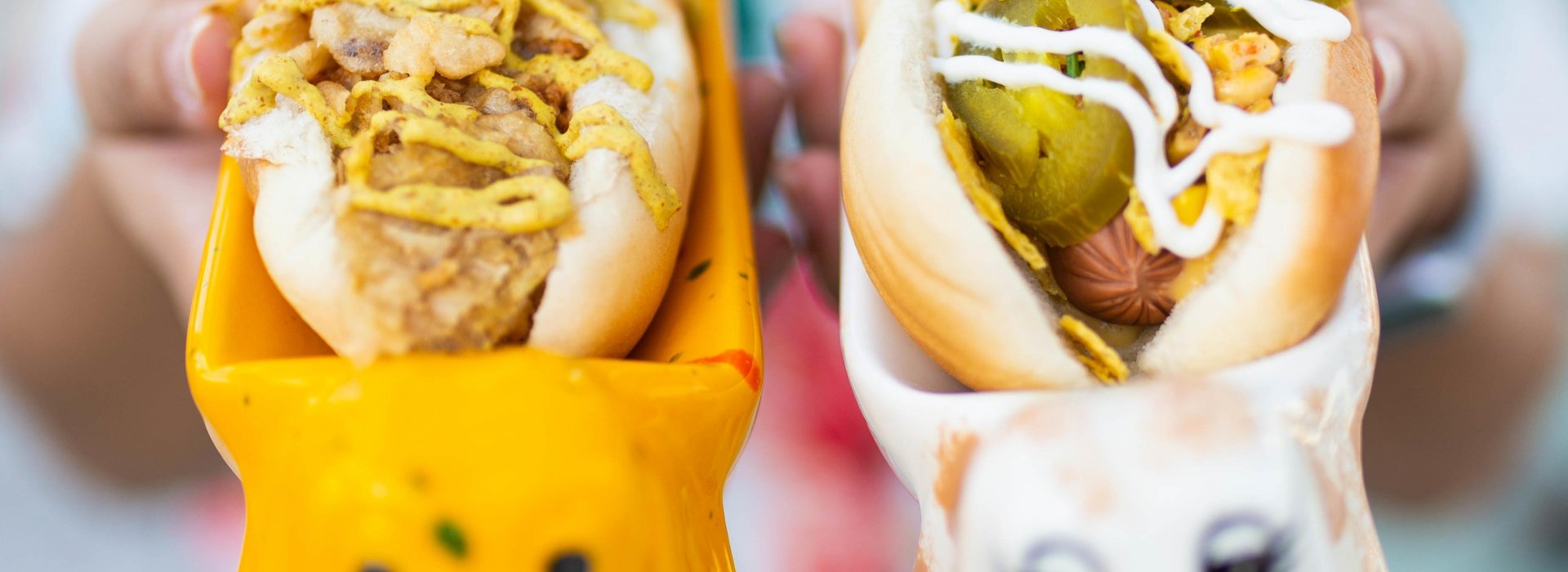 A woman holds up two vegan hot dogs