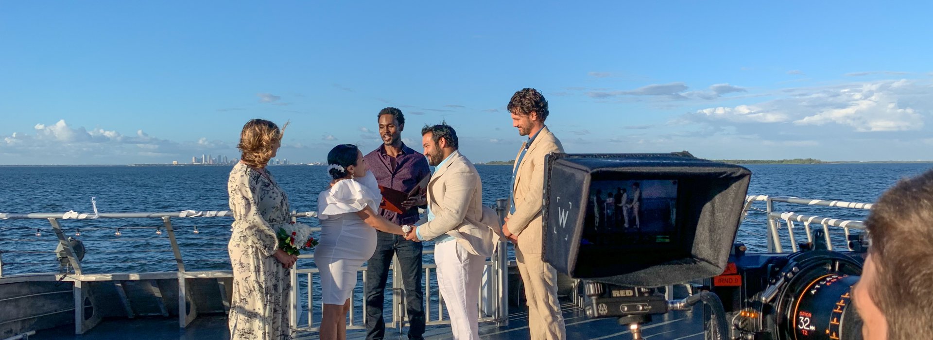 A man and a woman get married on a boat with a view of the water.