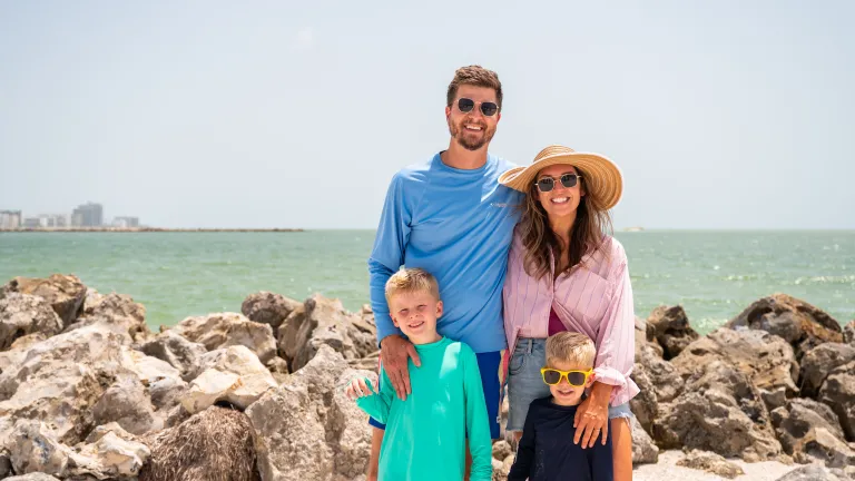 family standing on the beach