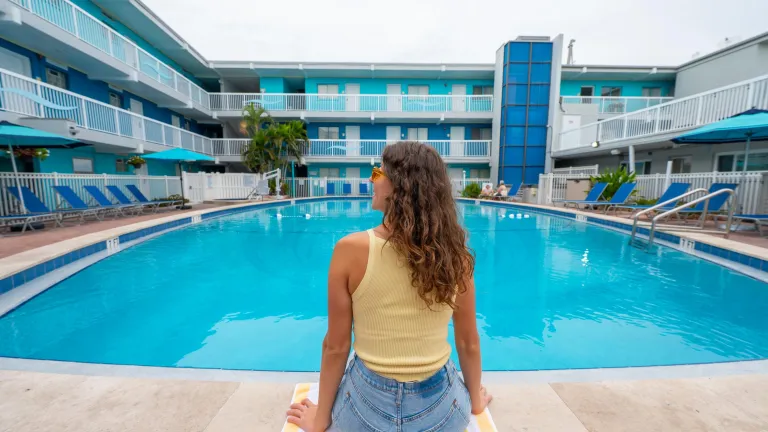 a woman sits poolside at the Bilmar Beach Resort
