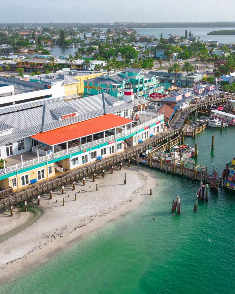 an aerial view of John's Pass Village & Boardwalk, a pier and a large boat