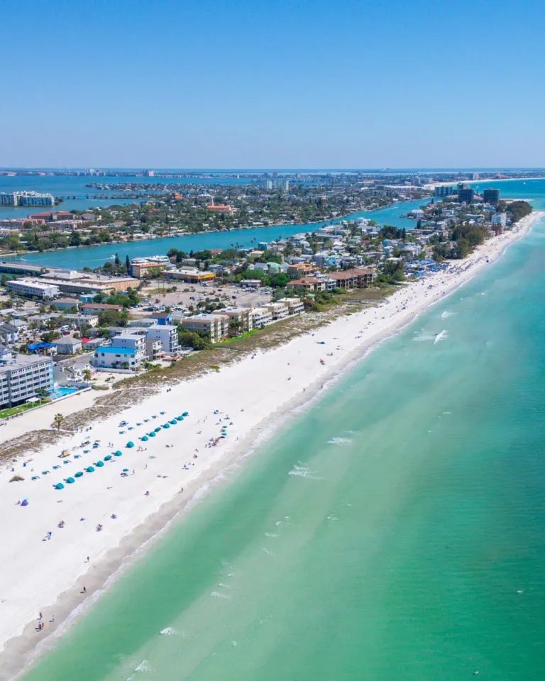 An aerial view of the ocean, beach and buildings along the shore