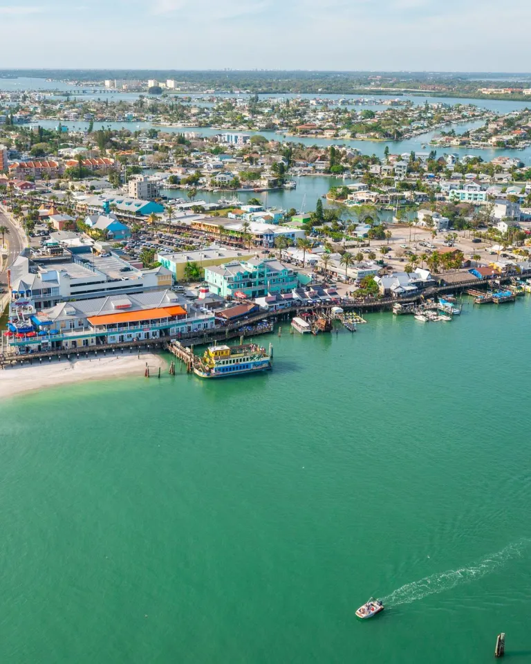aerial view of john's pass village with a bridge on the left and green inlet waters on the right
